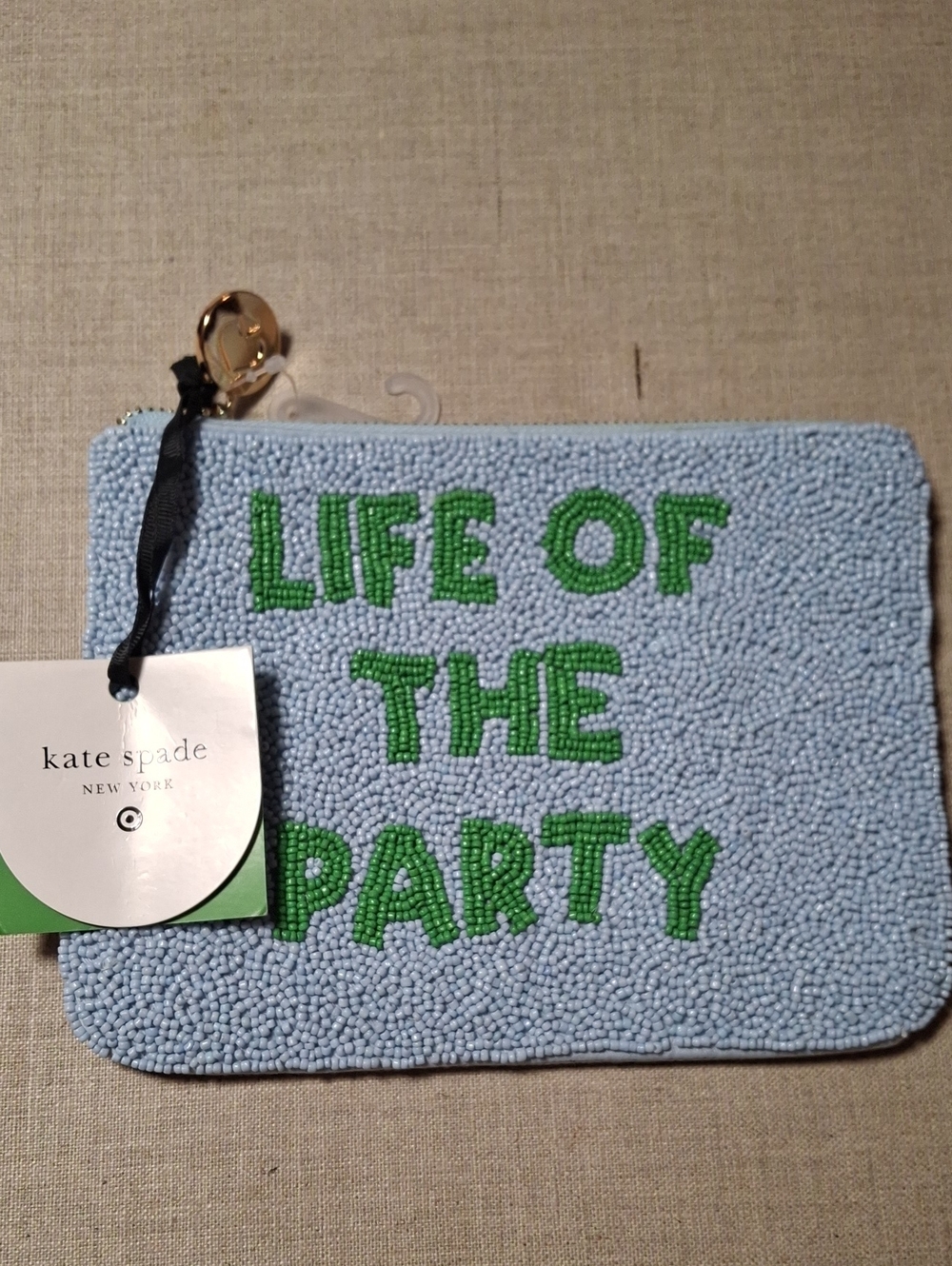 kate spade light blue beaded pouch with green lettering